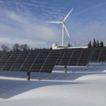 Renewable Energy - Solar Panels on Snow With Windmill Under Clear Day Sky