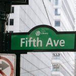 AI Public Safety - Metal post with direction indicator on avenue with high skyscrapers in New York