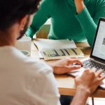 Remote Work - Woman In Green Long Sleeve Shirt Sitting In Front Of A Man