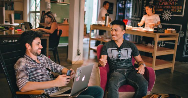 Coworking Space - Photograph of Men Having Conversation Seating on Chair