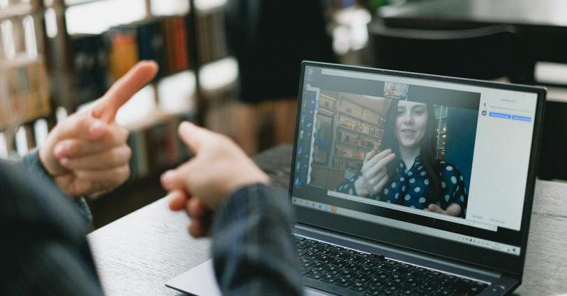 VR Language - Young lady learning sign language during online lesson with female tutor