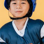 Skills Future - Satisfied ethnic child in American football player costume and helmet