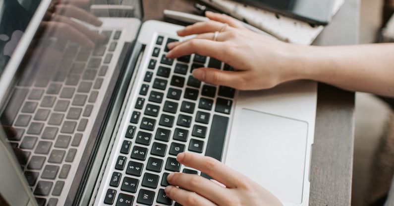 5G Remote Work - From above of unrecognizable woman sitting at table and typing on keyboard of computer during remote work in modern workspace