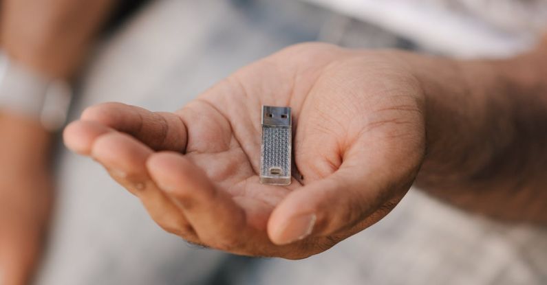 Small Business Digital - Crop unrecognizable male in casual clothes demonstrating modern portable memory card placed on hand