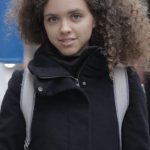 Smart Bus Stop - Serious young lady with book standing on bus stop on street