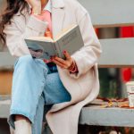 Urban Park - Young Woman Sitting on a Bench with a Book and Coffee