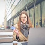 Accessible City - Woman in Brown Coat Holding a Bank Card