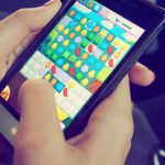 Mobile Gaming - Person Playing Candy Crush on Nokia Smartphone