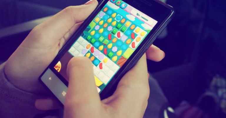 Mobile Gaming - Person Playing Candy Crush on Nokia Smartphone