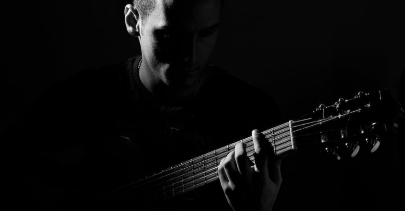 Games Pop Culture - Grayscale Photo of Man Playing Guitar