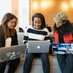 Women In Tech - three women sitting on sofa with MacBook