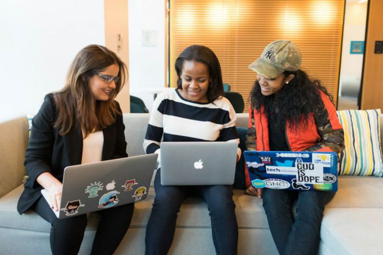 Women In Tech - three women sitting on sofa with MacBook