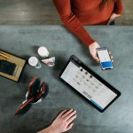 Square Payments - person holding smartphone beside tablet computer